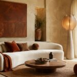 Warm living room with curved sofa, textured walls and earthy decor