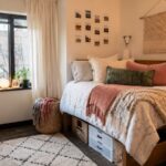 Layered dorm bedding with colorful pillows and a cozy throw in a small college room